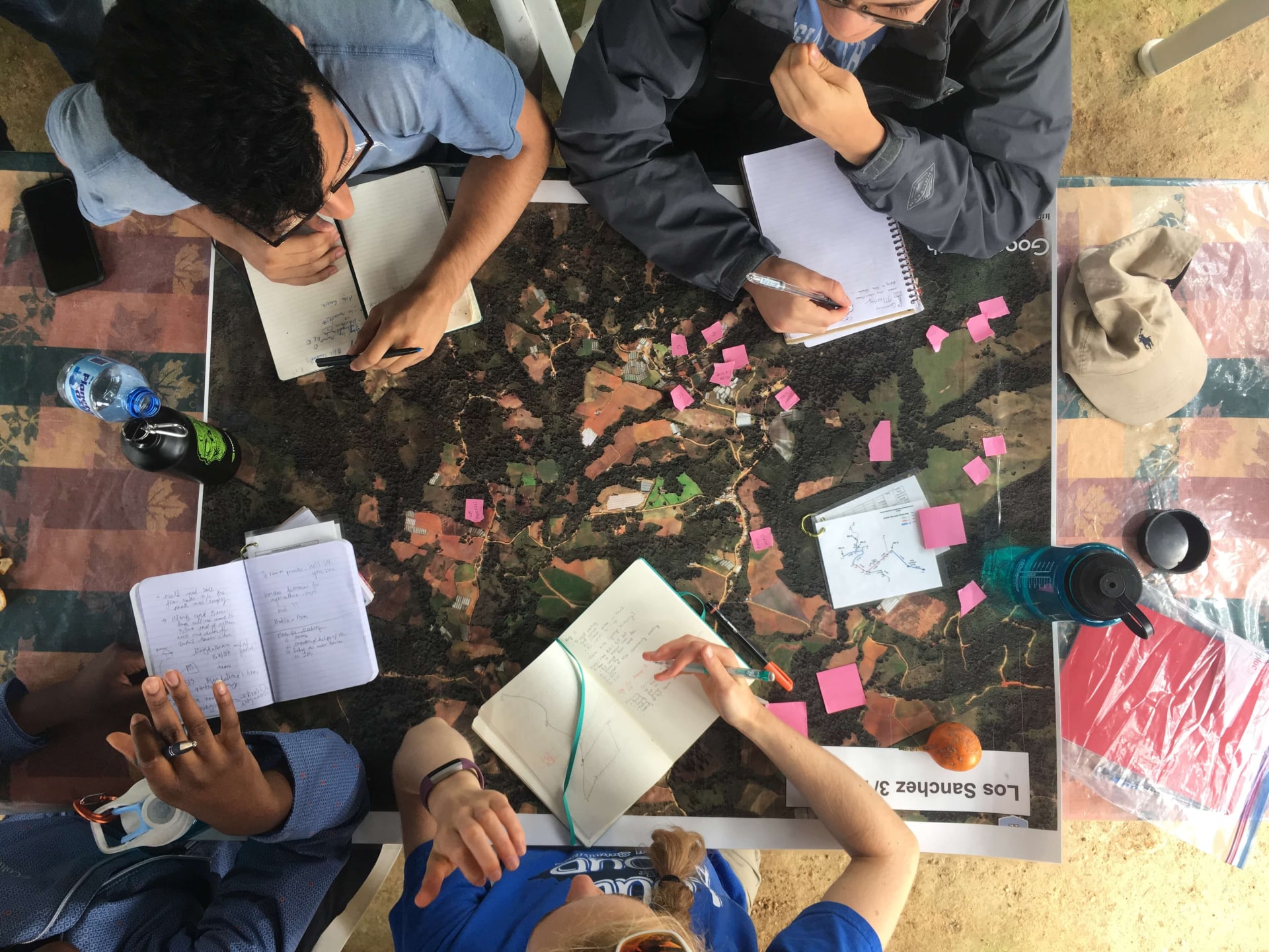 a group of people sitting around a table with notebooks