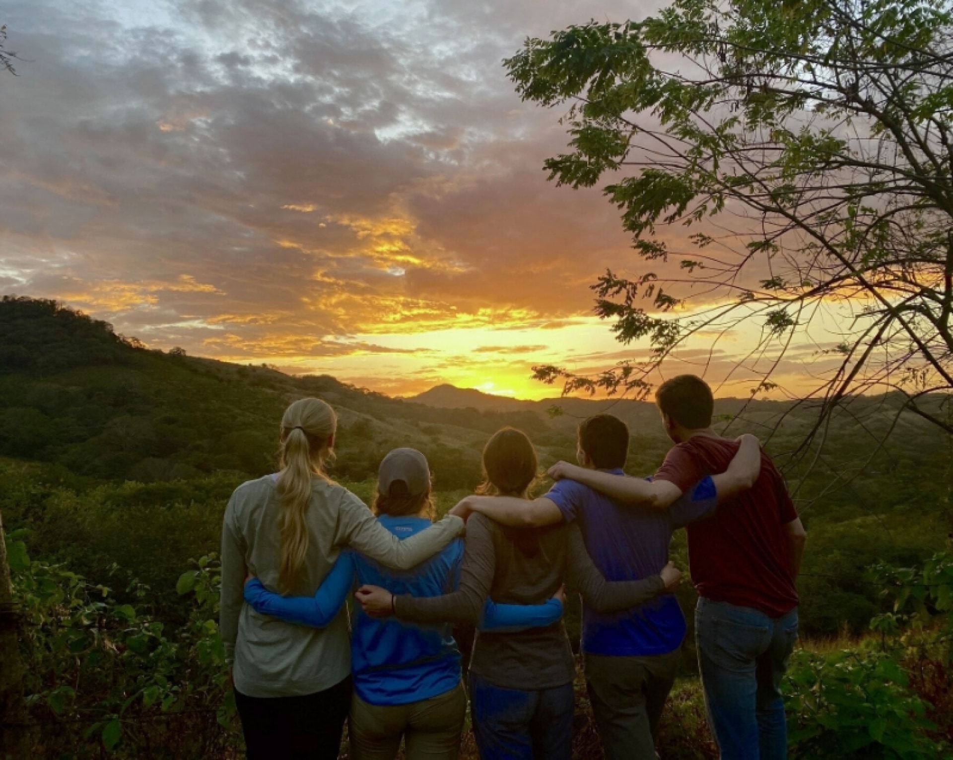 a group of people standing together with their arms around each other