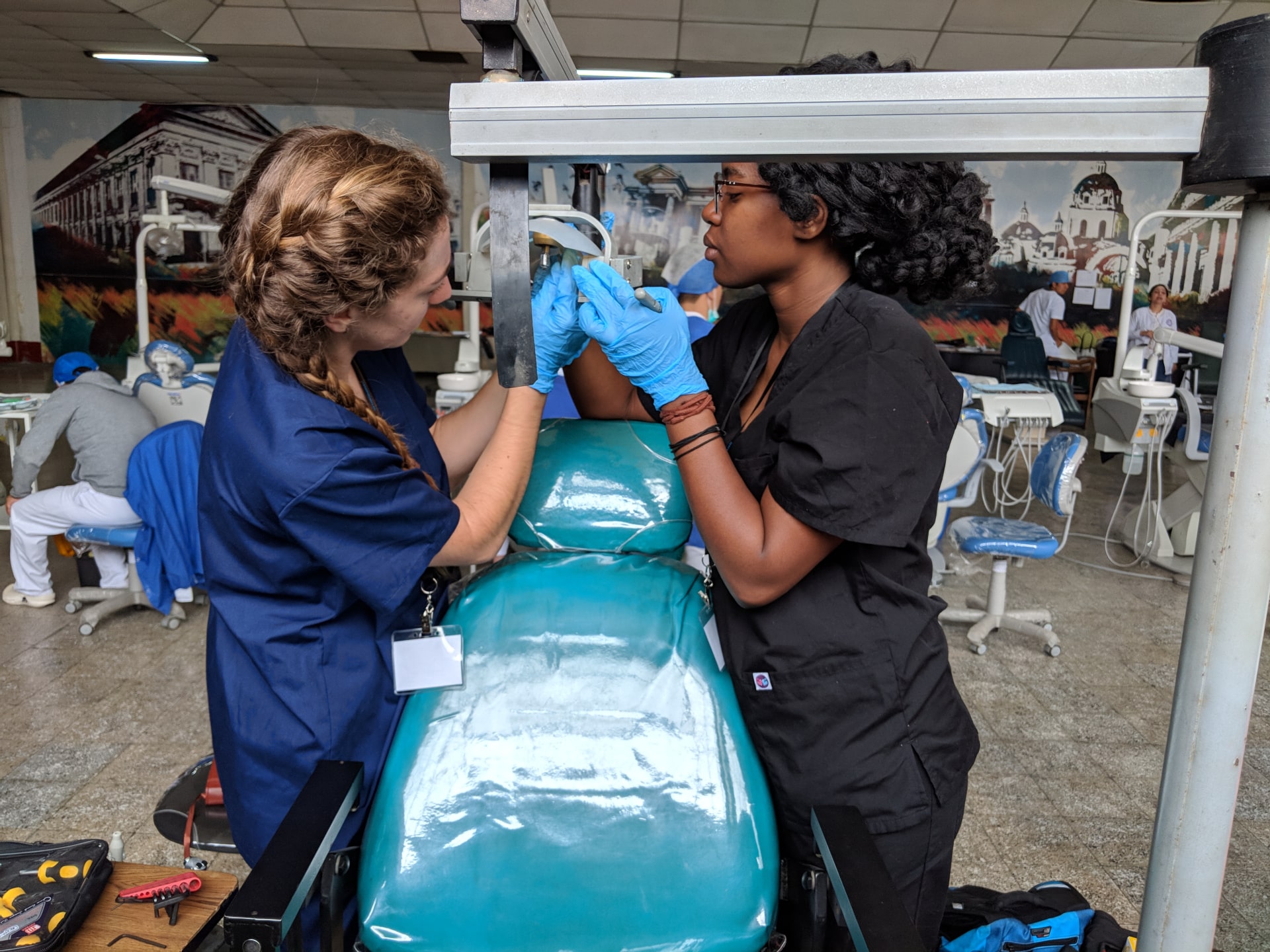 Two young women use their biomedical engineering skills to fix a dental chair