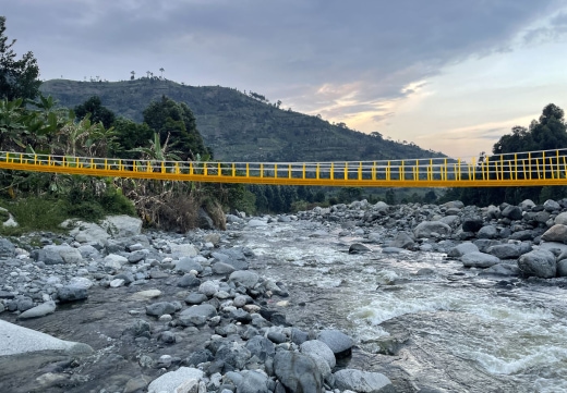 a yellow bridge over a river