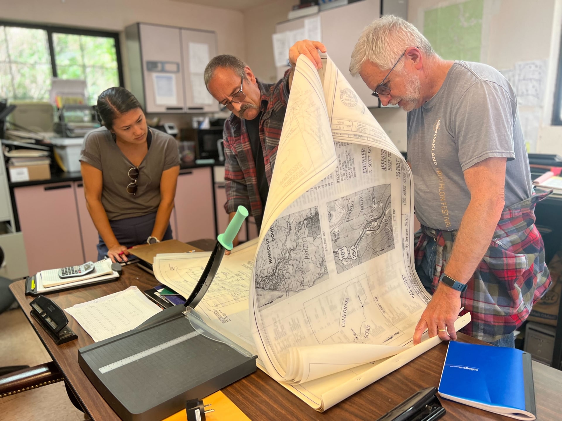 a group of people looking at a large piece of paper