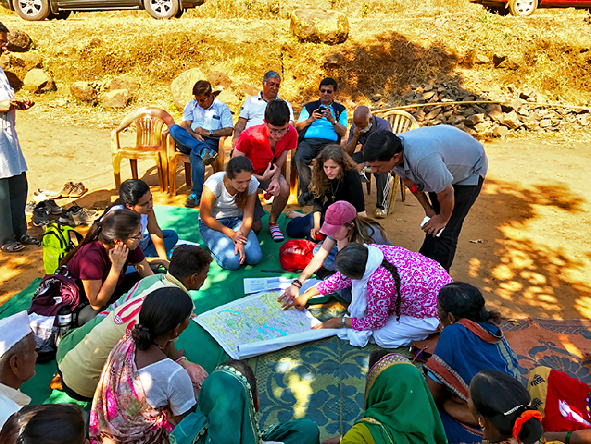 a group of people sitting around a map